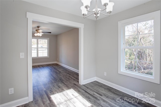 spare room with dark wood-type flooring and ceiling fan with notable chandelier