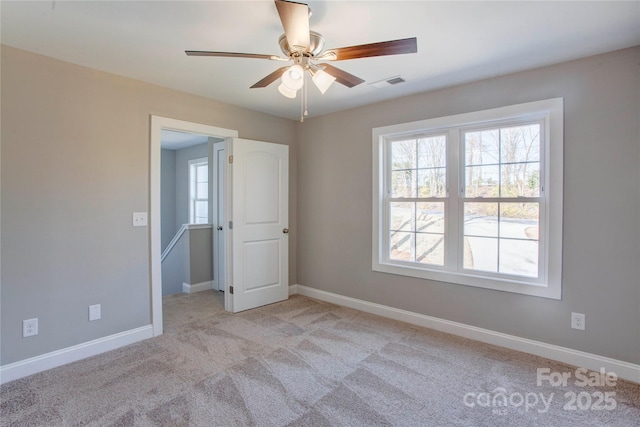 carpeted spare room with ceiling fan