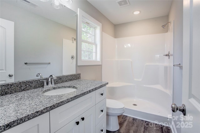 bathroom with vanity, wood-type flooring, toilet, and walk in shower