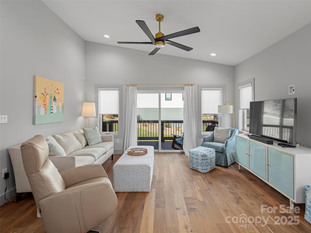 living room featuring plenty of natural light, ceiling fan, wood-type flooring, and high vaulted ceiling