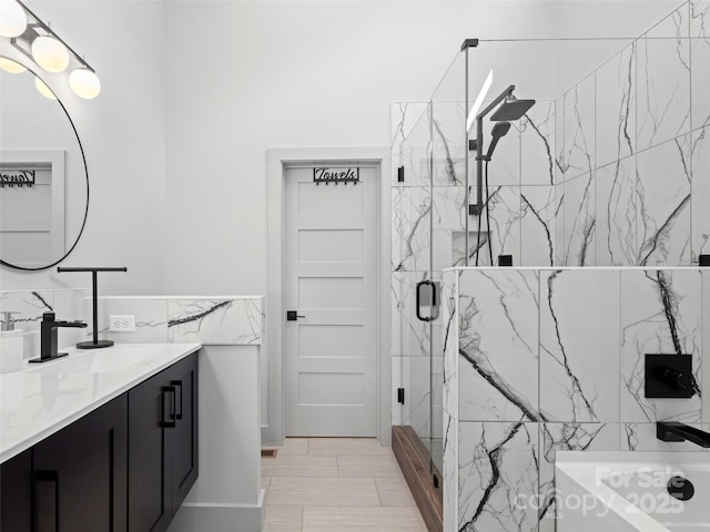 bathroom featuring vanity, a shower with shower door, and tile walls