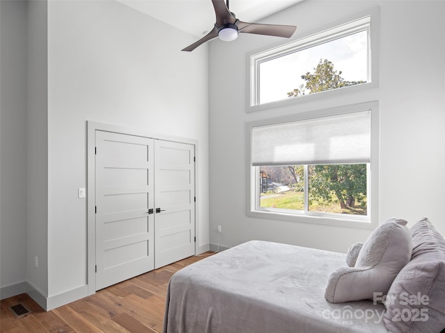 bedroom featuring ceiling fan, wood-type flooring, and a closet