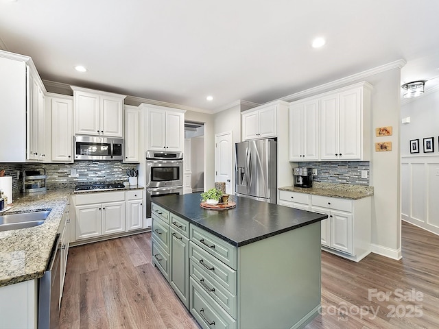 kitchen featuring light hardwood / wood-style flooring, decorative backsplash, a kitchen island, white cabinetry, and stainless steel appliances