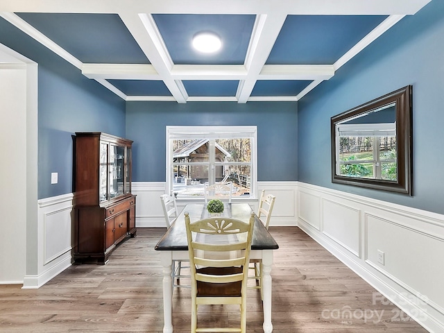 dining area with a healthy amount of sunlight, light hardwood / wood-style floors, coffered ceiling, and beam ceiling