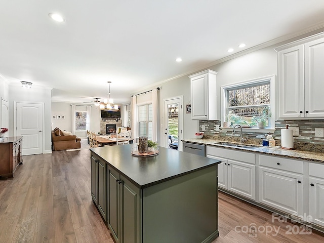 kitchen with backsplash, white cabinetry, sink, and a center island