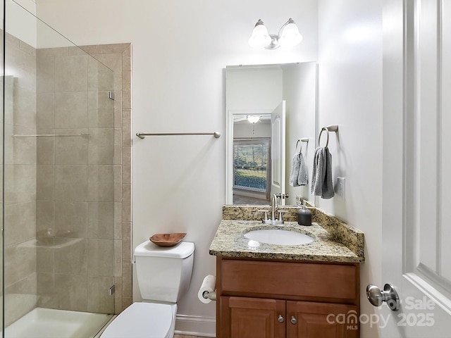 bathroom featuring vanity, toilet, and a shower with shower door