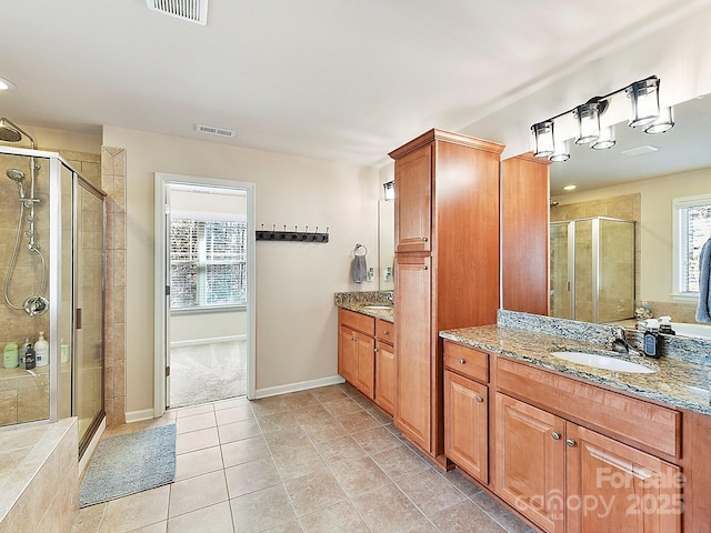 bathroom with tile patterned flooring, vanity, and an enclosed shower