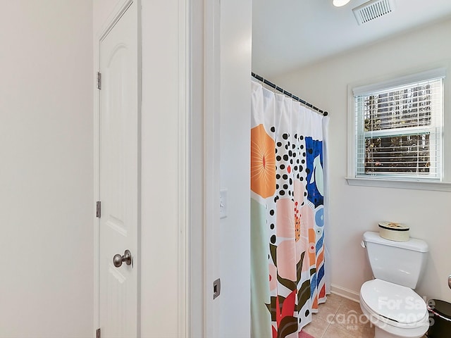 bathroom with tile patterned flooring, a shower with curtain, and toilet