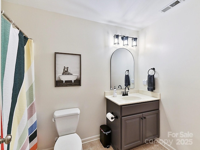 bathroom with tile patterned flooring, vanity, and toilet