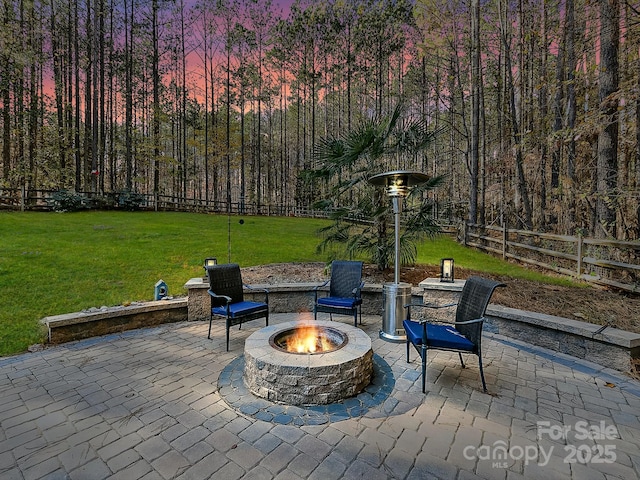 patio terrace at dusk with a yard and an outdoor fire pit