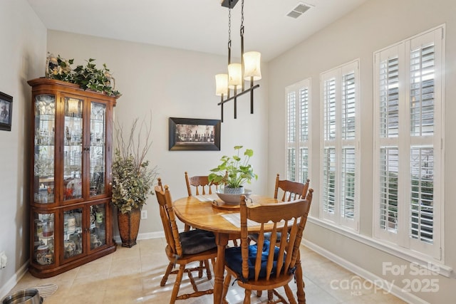 tiled dining area featuring a chandelier