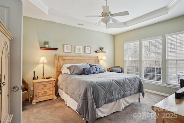 carpeted bedroom with a raised ceiling and ceiling fan