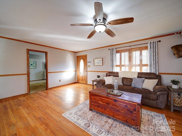 living room featuring crown molding, light hardwood / wood-style floors, and ceiling fan