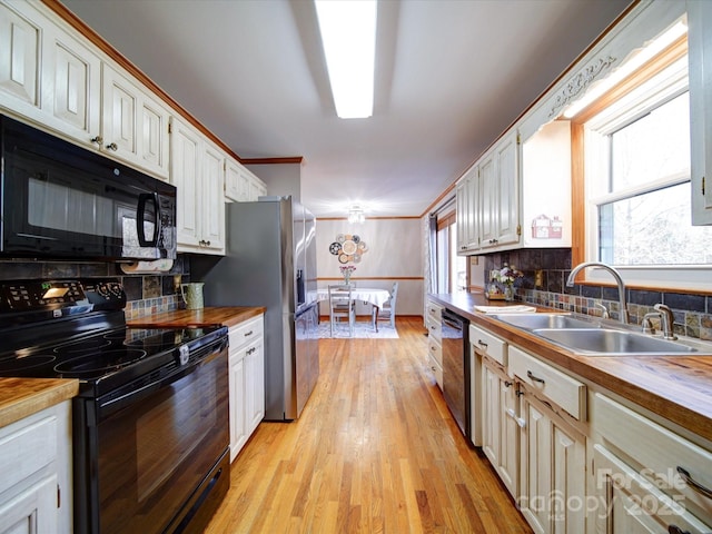 kitchen featuring white cabinetry, sink, black appliances, and wooden counters