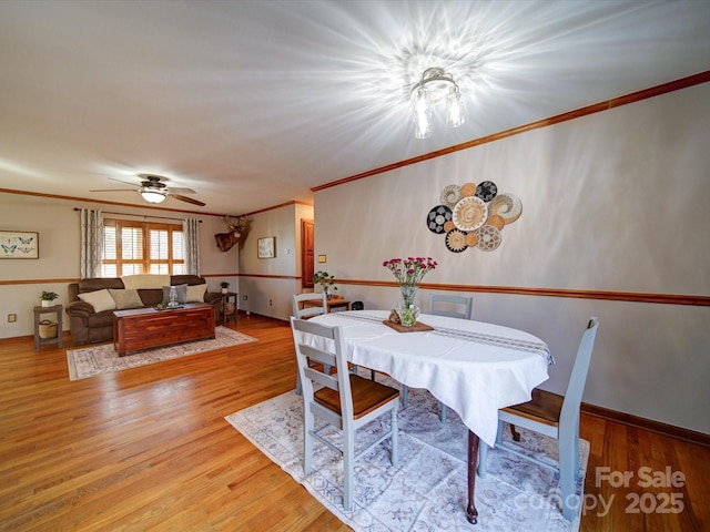 dining room featuring crown molding, ceiling fan, and light wood-type flooring