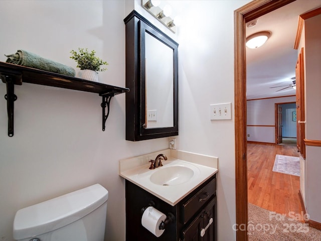 bathroom with hardwood / wood-style flooring, vanity, and toilet