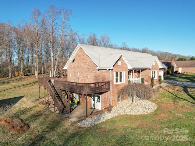 rear view of house with a wooden deck and a lawn