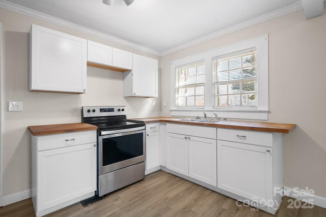 kitchen with white cabinets, sink, butcher block counters, and electric stove