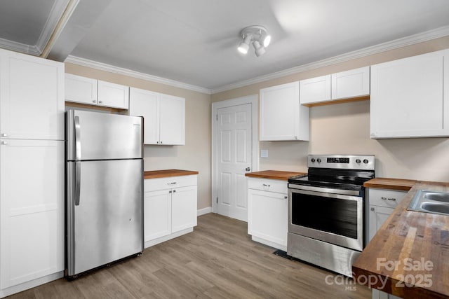 kitchen with stainless steel appliances, white cabinetry, wooden counters, and ornamental molding