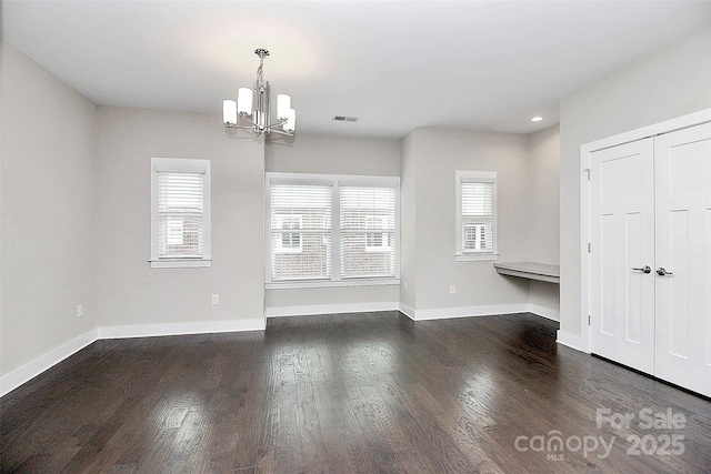 interior space featuring dark hardwood / wood-style floors, a wealth of natural light, and a notable chandelier