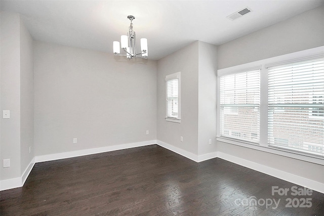 unfurnished room with dark hardwood / wood-style floors and an inviting chandelier