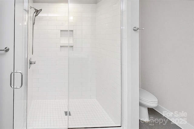 bathroom with toilet and a shower with shower door