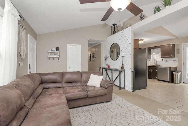 tiled living room featuring lofted ceiling, sink, and ceiling fan