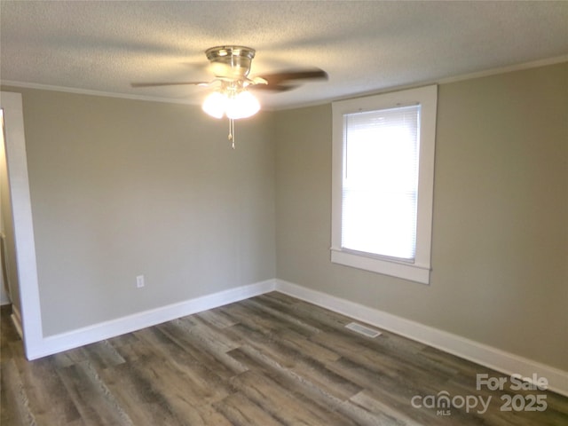 empty room with a textured ceiling, ceiling fan, crown molding, and dark hardwood / wood-style floors