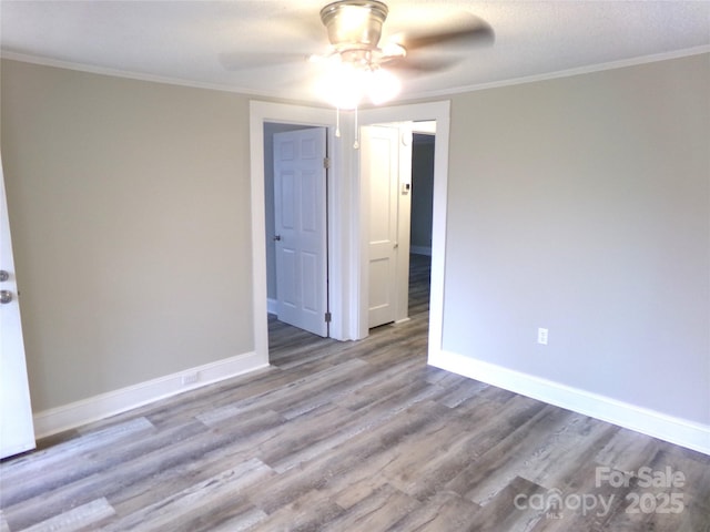 spare room featuring ceiling fan, light wood-type flooring, and ornamental molding