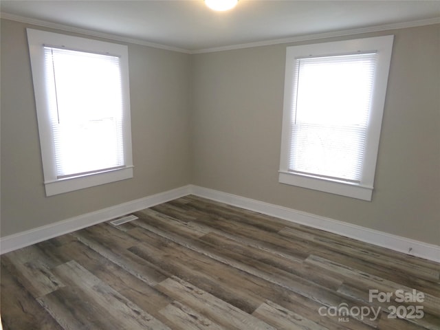 spare room featuring dark hardwood / wood-style flooring and crown molding