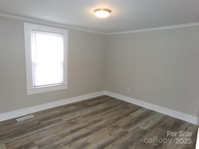 spare room featuring crown molding and dark hardwood / wood-style floors