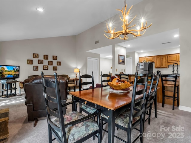 carpeted dining area with a chandelier, lofted ceiling, and sink