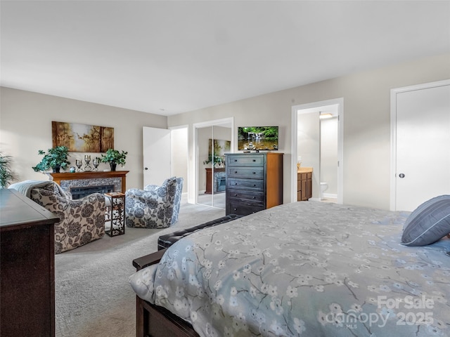 bedroom with light carpet and ensuite bathroom