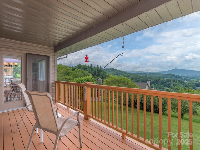 wooden terrace with a mountain view and a lawn