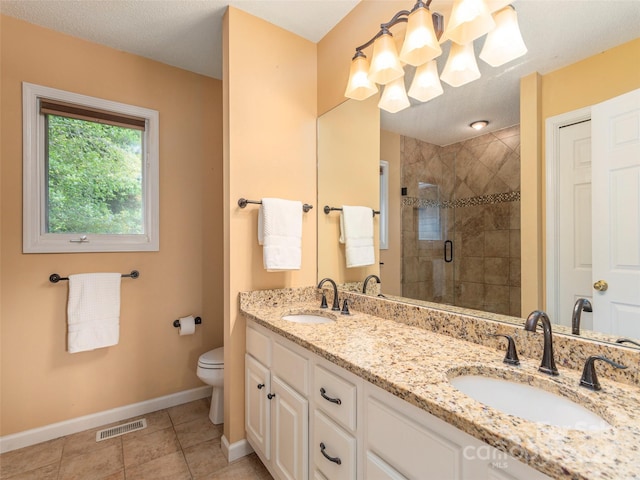 bathroom with tile patterned floors, toilet, vanity, and walk in shower