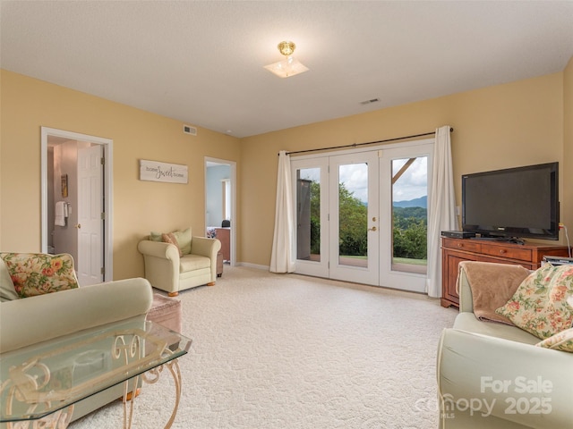 living room with french doors and light colored carpet