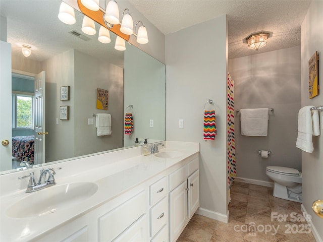 bathroom with vanity, a textured ceiling, and toilet