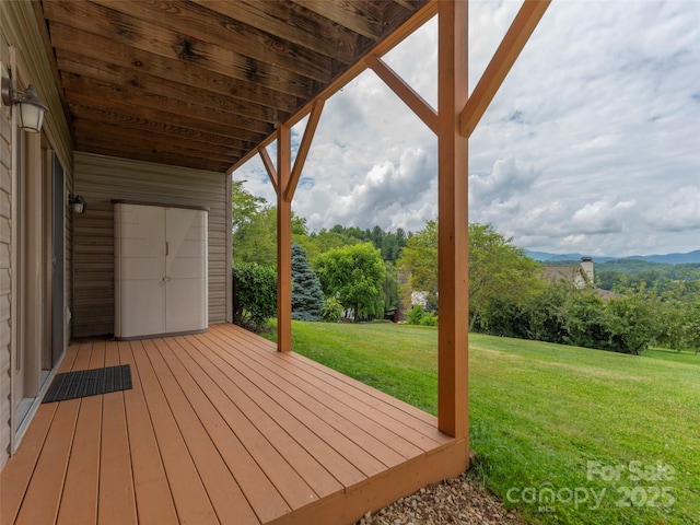 deck with a lawn and a mountain view