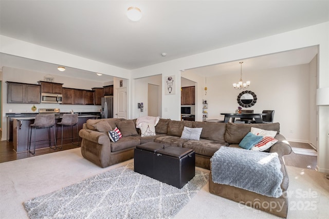 carpeted living room with a notable chandelier