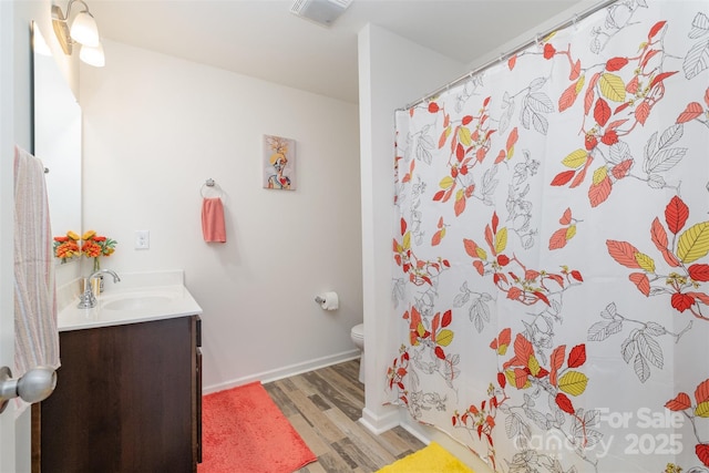 bathroom with curtained shower, hardwood / wood-style floors, vanity, and toilet