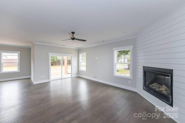 unfurnished living room featuring plenty of natural light, a large fireplace, and ornamental molding