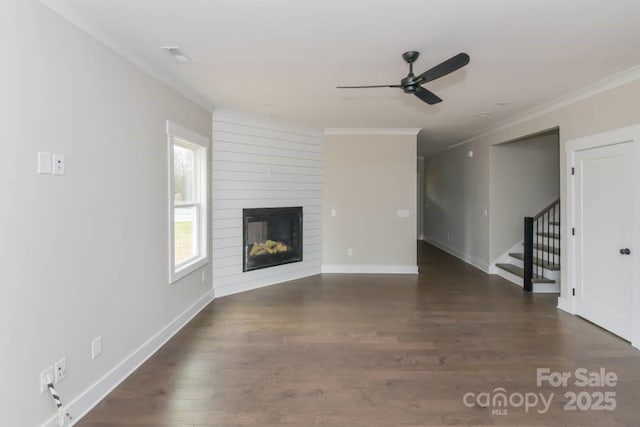 unfurnished living room featuring dark hardwood / wood-style flooring, ceiling fan, a fireplace, and ornamental molding