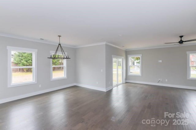 spare room featuring ceiling fan with notable chandelier, crown molding, and dark wood-type flooring