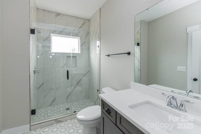 bathroom featuring a shower with door, vanity, and toilet