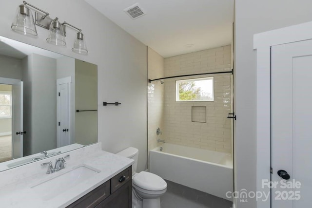 full bathroom with vanity, tiled shower / bath combo, and toilet