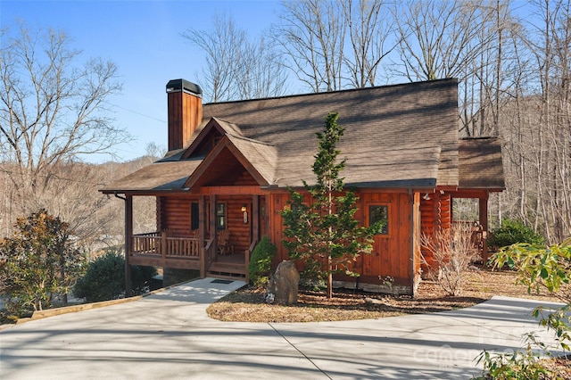 log-style house featuring covered porch