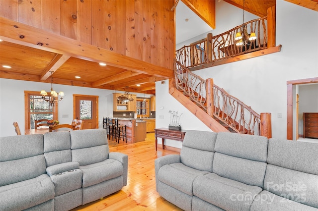 living room featuring wood-type flooring, beam ceiling, a chandelier, and wooden ceiling