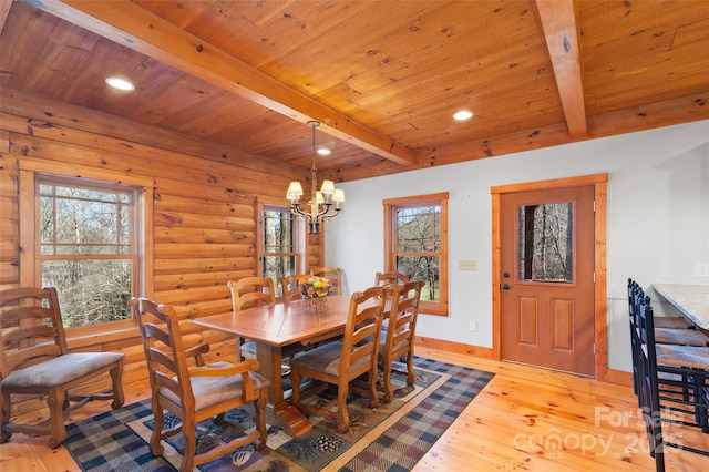 dining room with light wood-type flooring, rustic walls, and beam ceiling