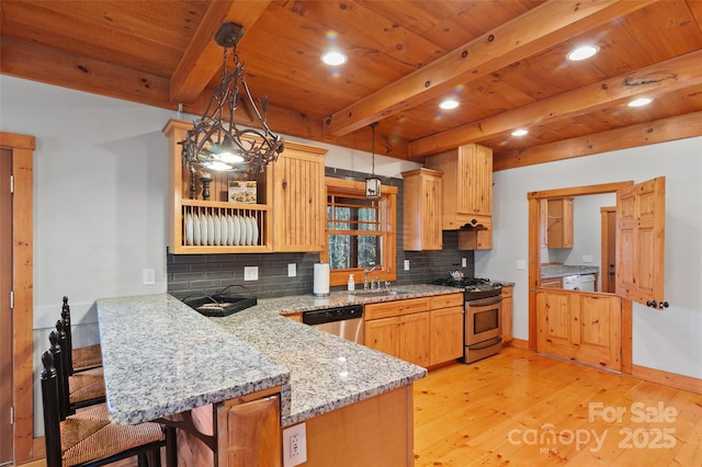 kitchen featuring sink, light hardwood / wood-style flooring, appliances with stainless steel finishes, kitchen peninsula, and pendant lighting