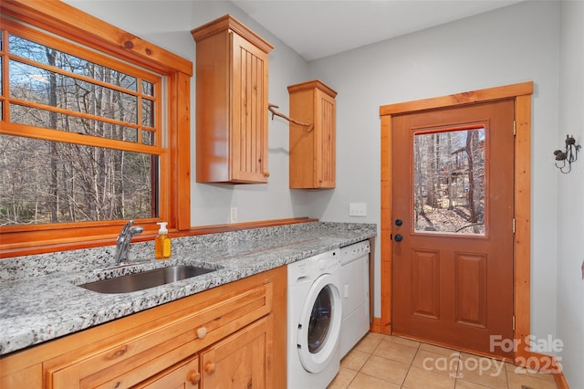 laundry room featuring light tile patterned flooring, cabinets, plenty of natural light, and sink